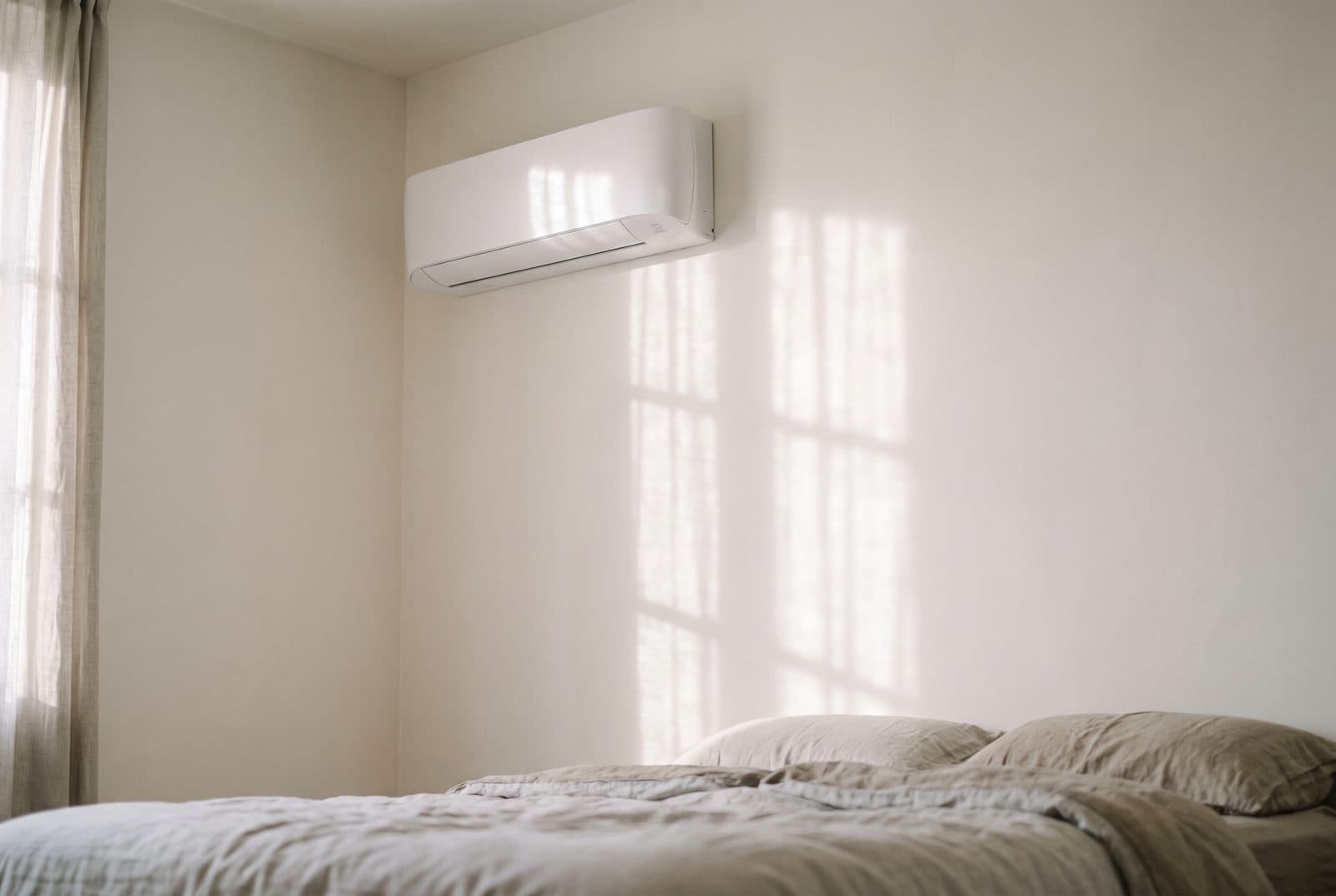 Climatizzatore split bianco installato a regola d'arte in una camera da letto